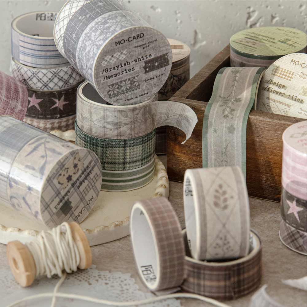 Collection of washi tape rolls with various designs on a wooden surface.