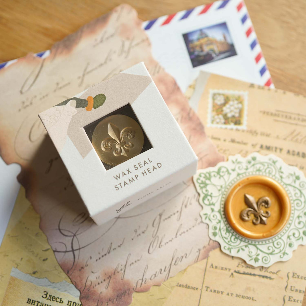 Fleur de lis 3D wax seal stamp head in a windowed gift box, with a gold wax seal on a lace doily and vintage letters. Fiona Ariva Australia