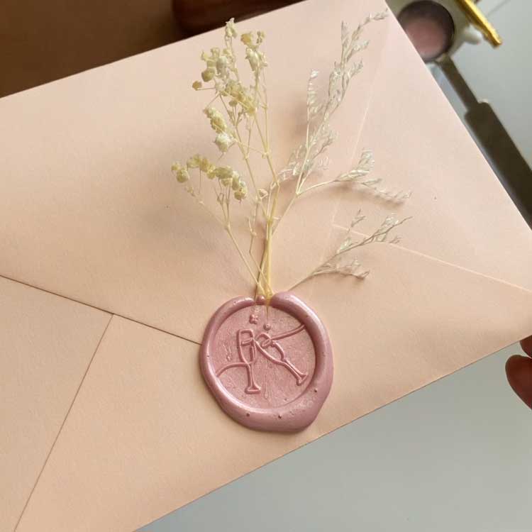 pink wax seal clinking champagne glasses
