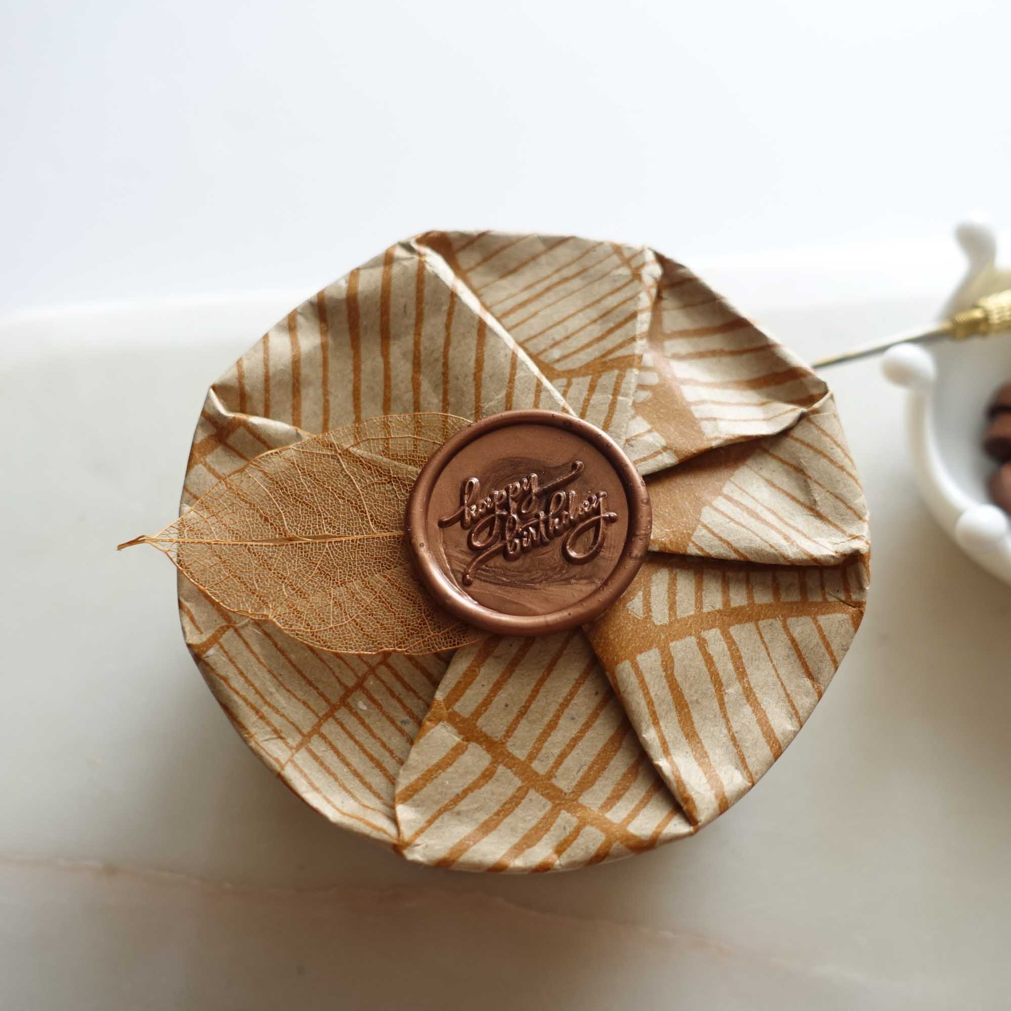 hickory brown sealing wax with happy birthday wax seal on wrapped gift with skeleton leaf