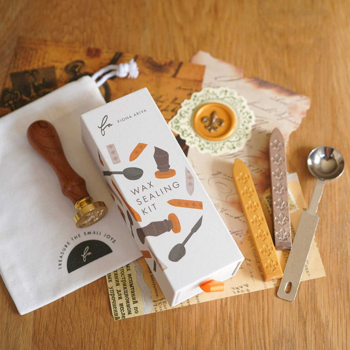 Fleur de lis wax sealing kit with wooden handle stamp, sealing wax sticks, melting spoon, gift box and a gold fleur de lis wax seal. Fiona Ariva Australia