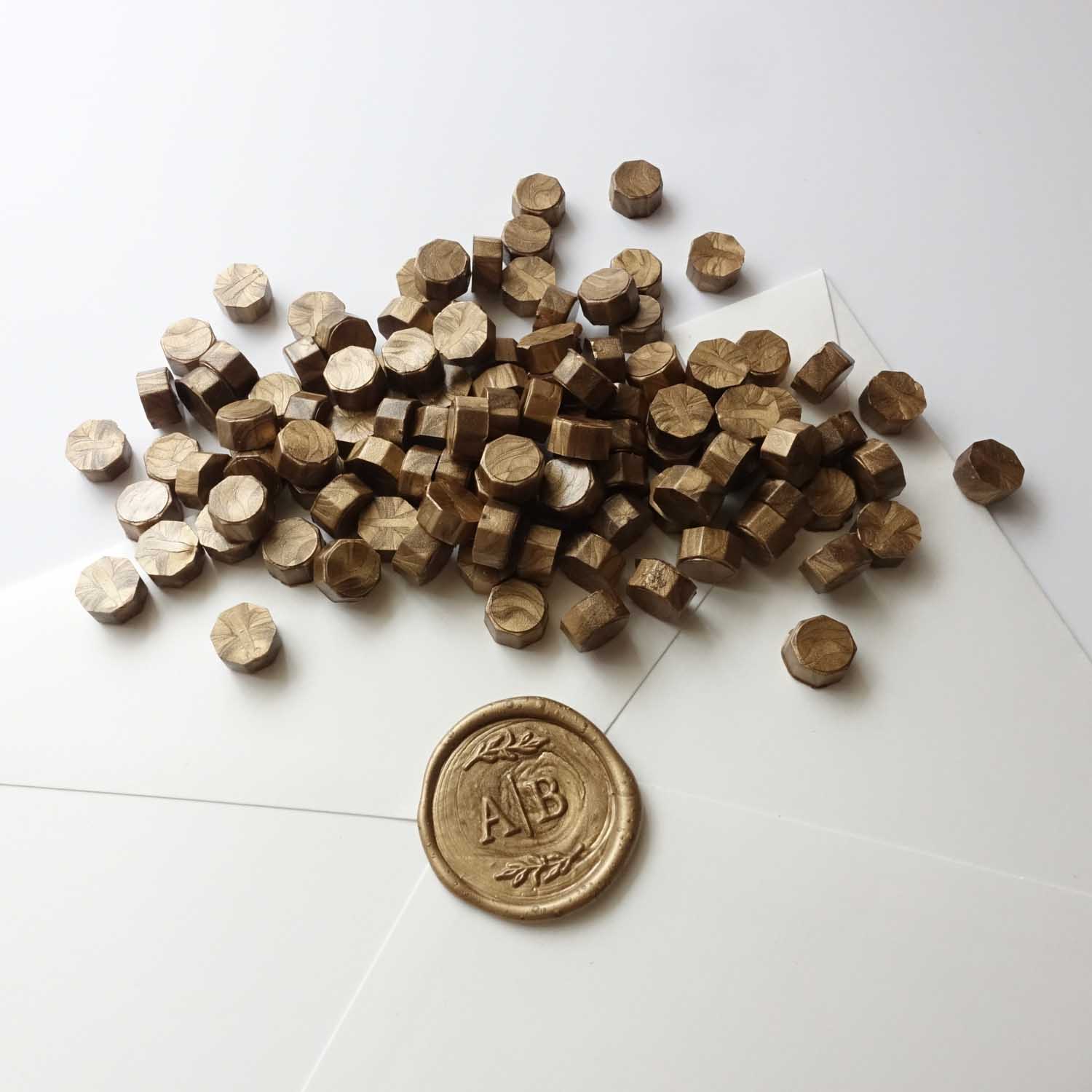 Bronze gold wax beads pellets granules with monogram initials wax seal on white envelope