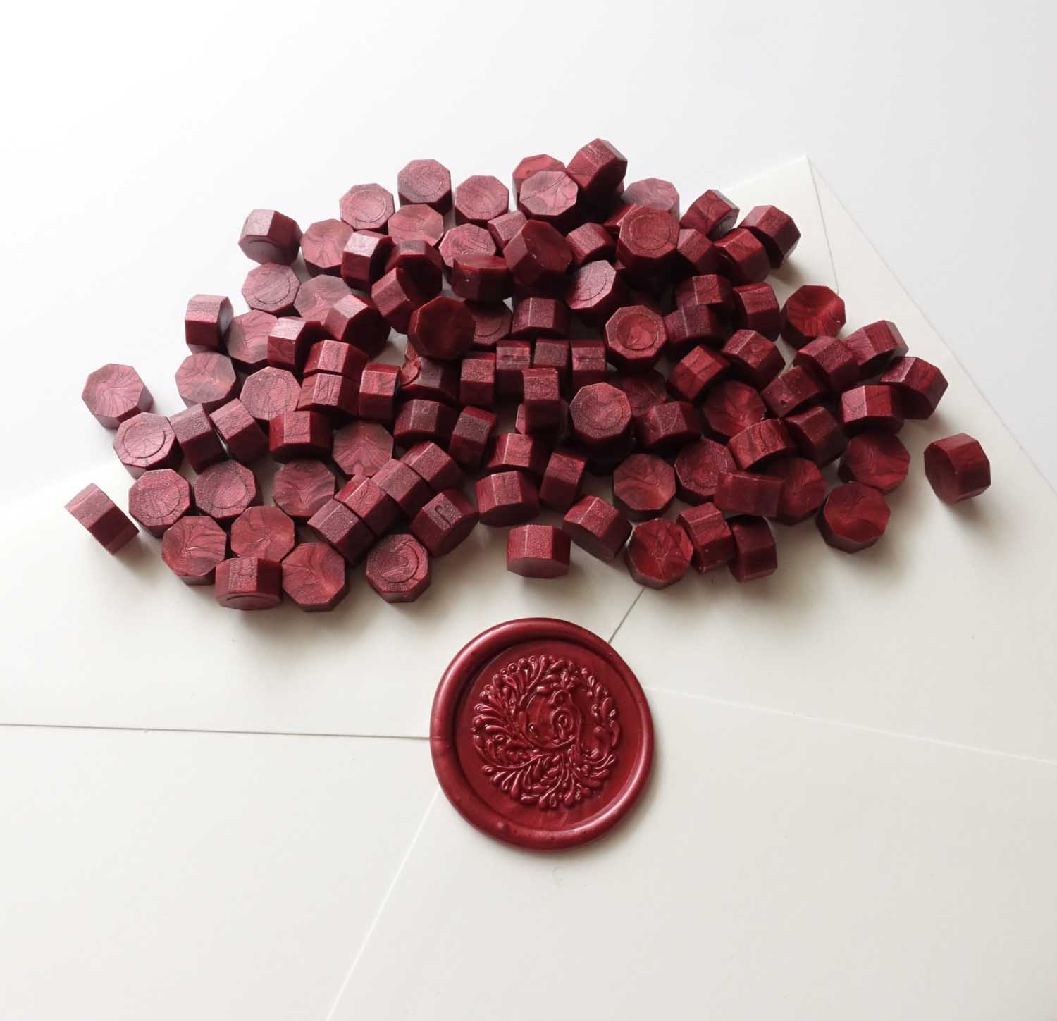 Burgundy wax beads pellets granules with song bird wax seal on white envelope