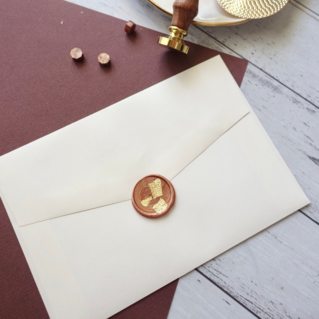 Wax seal on envelope with gold leaf and blank stamp plus wax beads