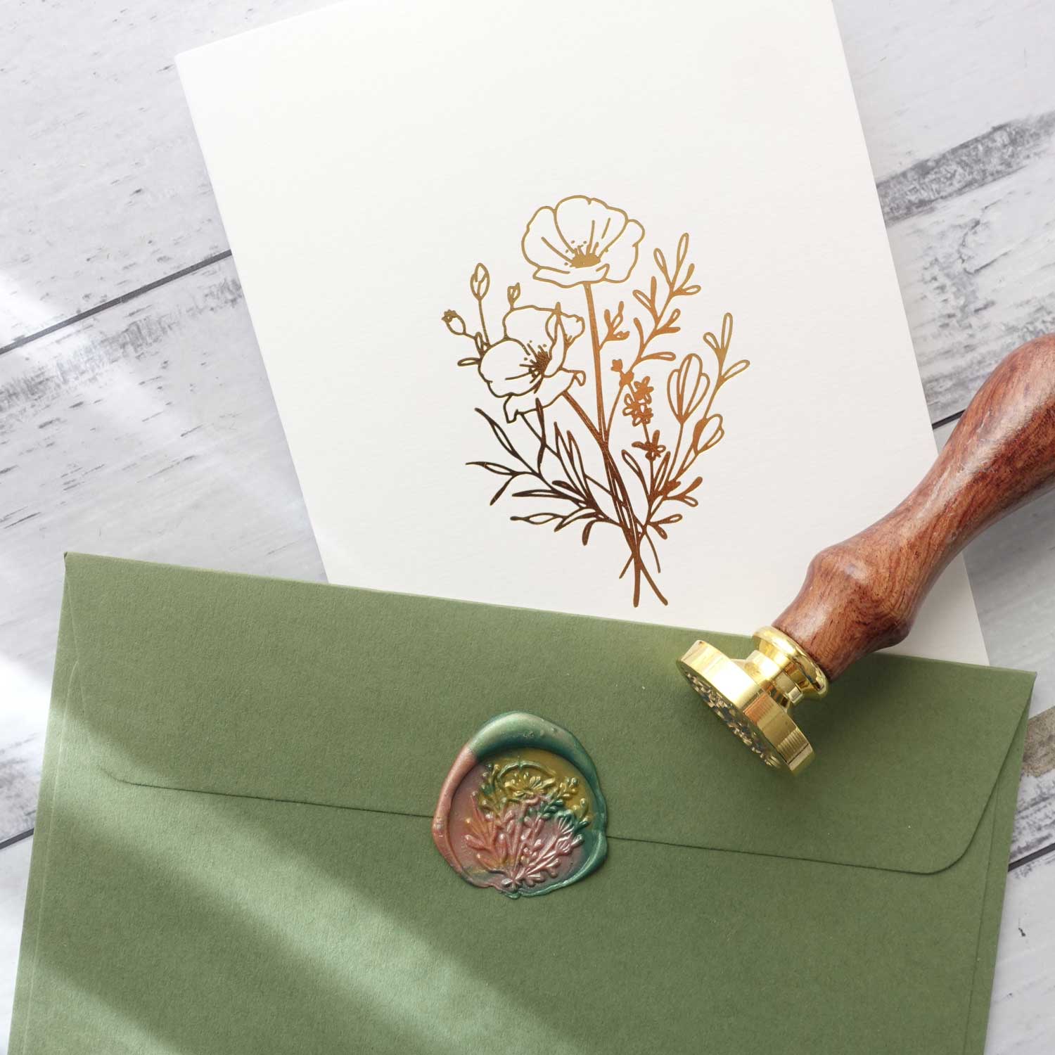 Gold foiled greeting card with wild flower wax seal stamp on green envelope
