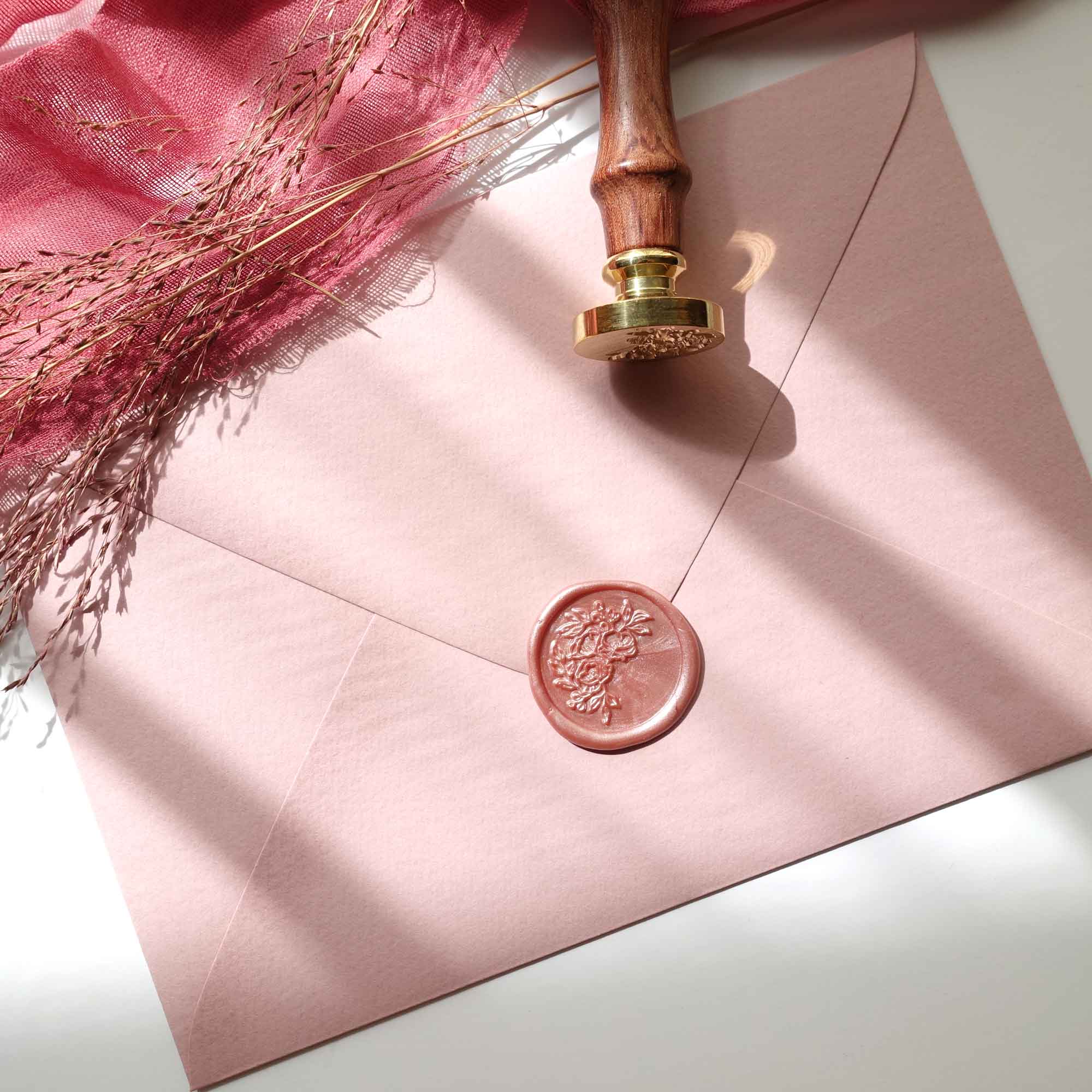 Dusty rose half garland wax seal on wedding invitations envelope